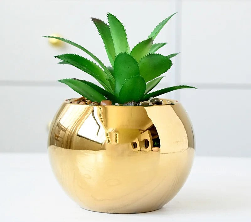 Two mint green marble vases on gold iron stands on table

