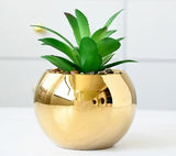Two mint green marble vases on gold iron stands on table
