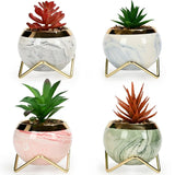 Two white marble vases with gold stands on shelf

